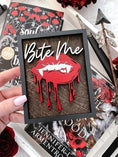 Load image into Gallery viewer, Bite Me Shelf Sign - FireDrake Artistry® wooden sign with natural background, dark grey frams, white "Bite Me" wording and red vampire lips. 
